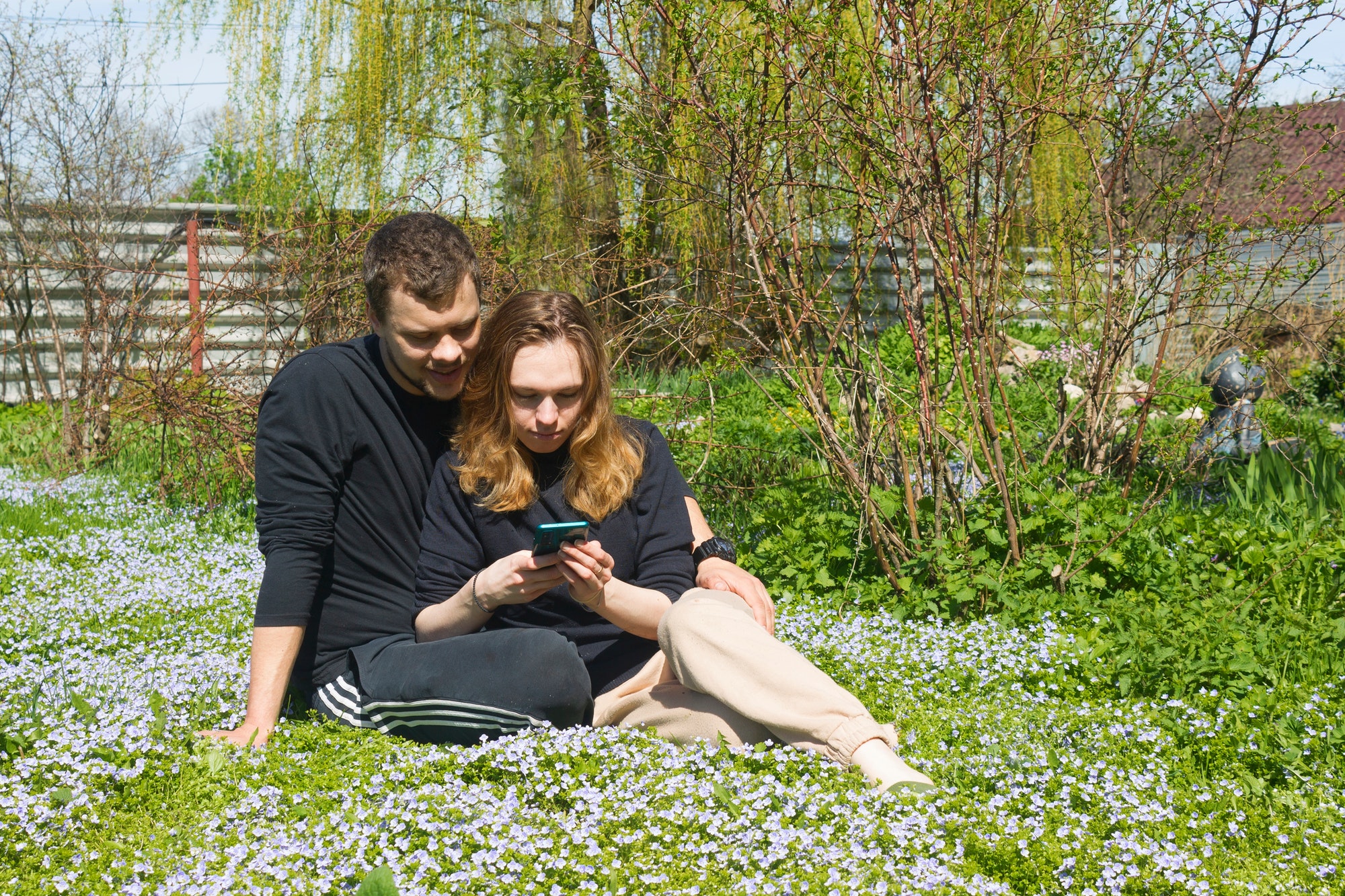 A young couple of lovers have fun and relax in a flower meadow.