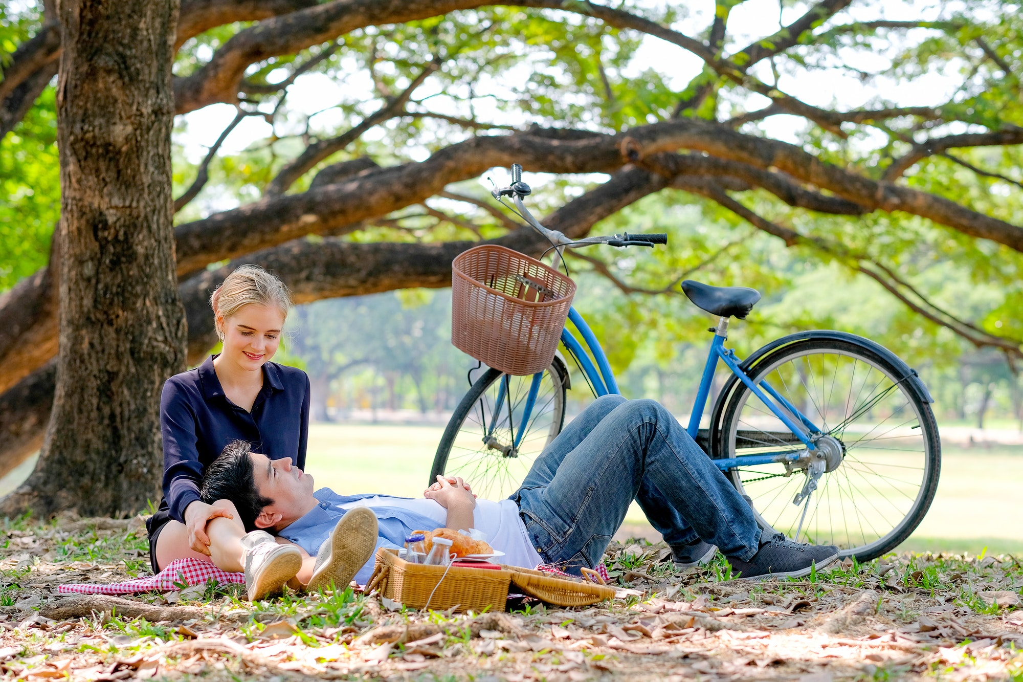 Couple lovers have picnic activity in the garden with blond hair girl with handsome man