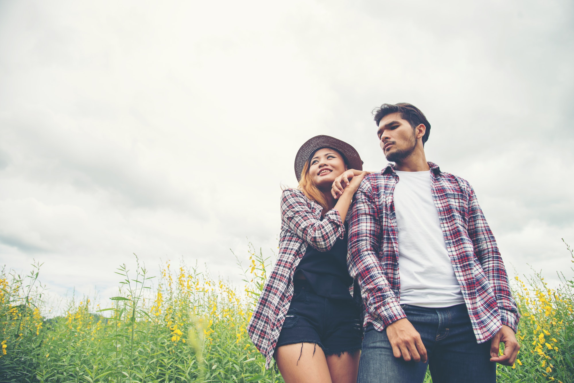 Young hipster couple lovers strolling in a field of flowers,relaxing time,Enjoyment with nature.